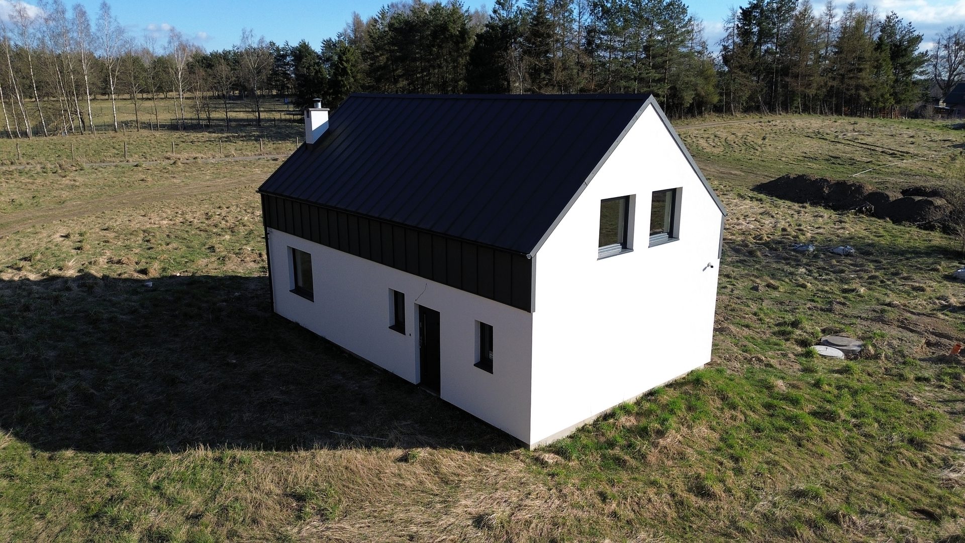 Dom z boku, las w tle